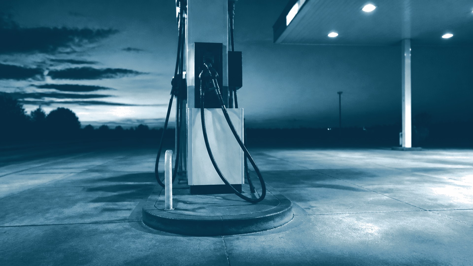 Bico de bomba de combustível em posto vazio ao entardecer