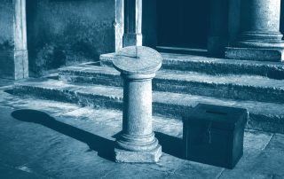 Relógio de sol projetando sombra longa sobre urna eleitoral fechada