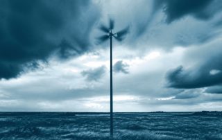 Cata-vento girando descontrolado em poste isolado sob nuvens de tempestade