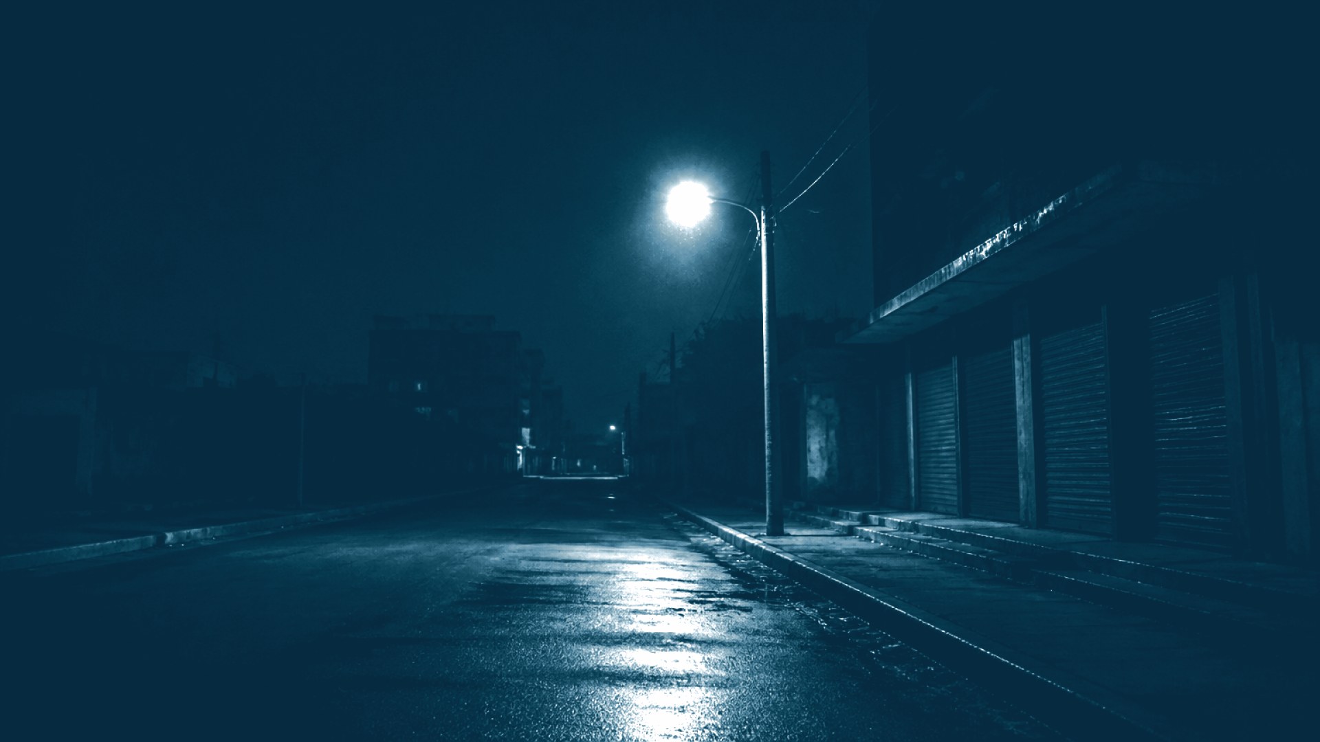 Poste de luz piscando em rua escura durante apagão