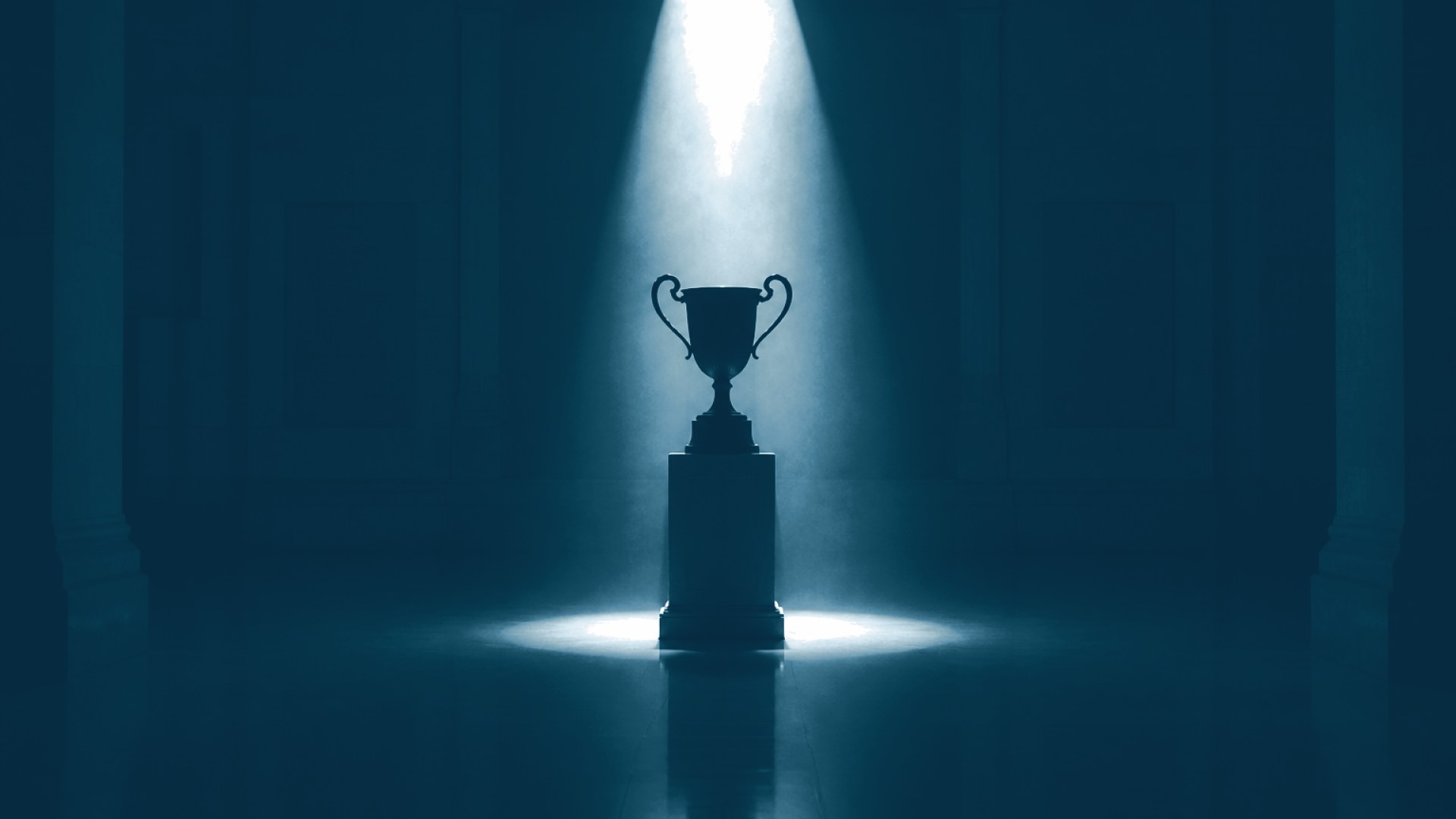 Silhueta de troféu sobre pedestal em salão institucional escuro