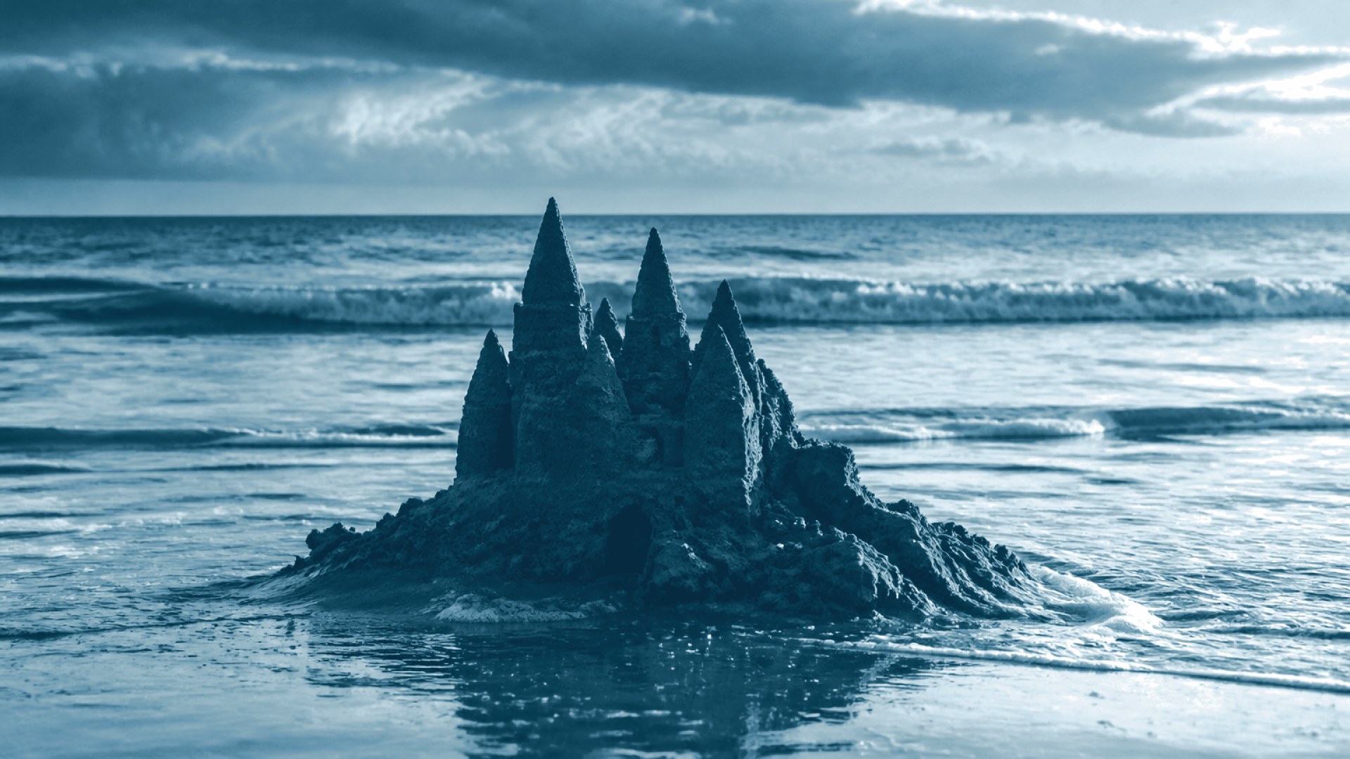 Castelo de areia desmoronando com a maré subindo