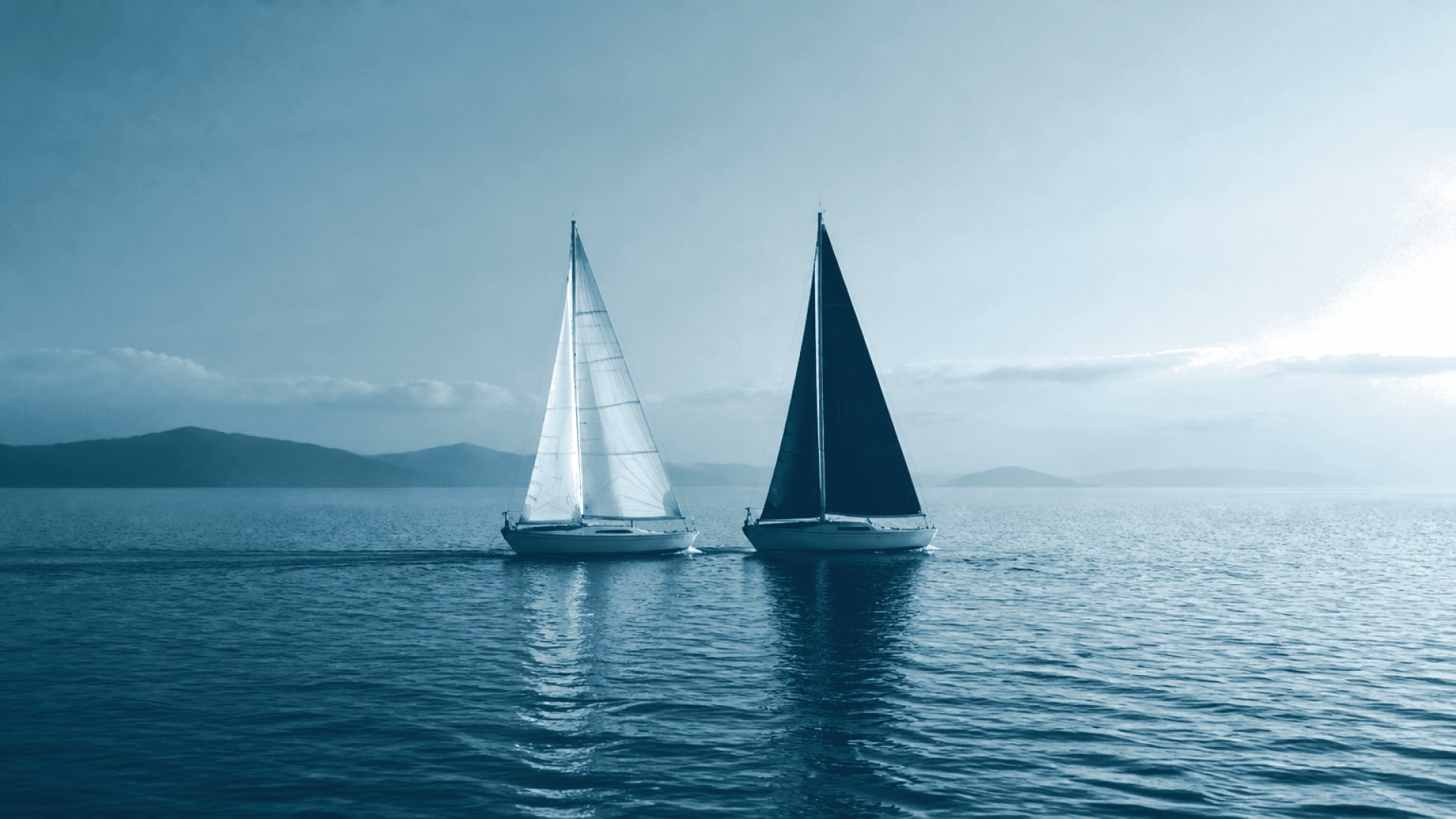 Dois pequenos barcos avançando lado a lado em velocidade igual