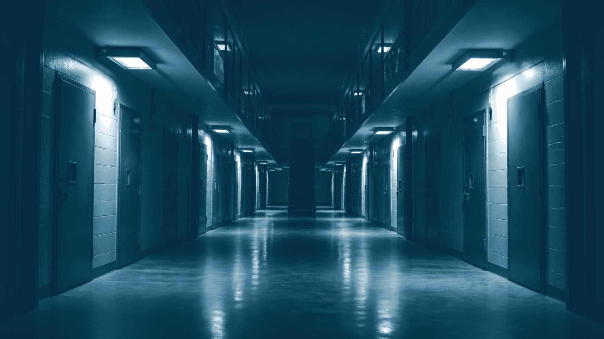 Corredor de presídio vazio com portas de cela fechadas
