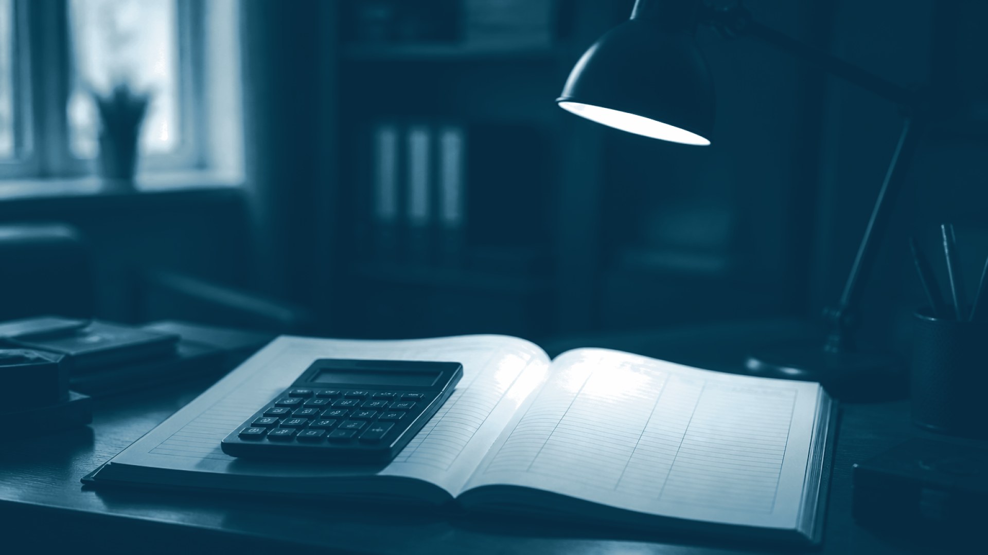 Calculadora pousada sobre livro-razão de páginas em branco e vazias